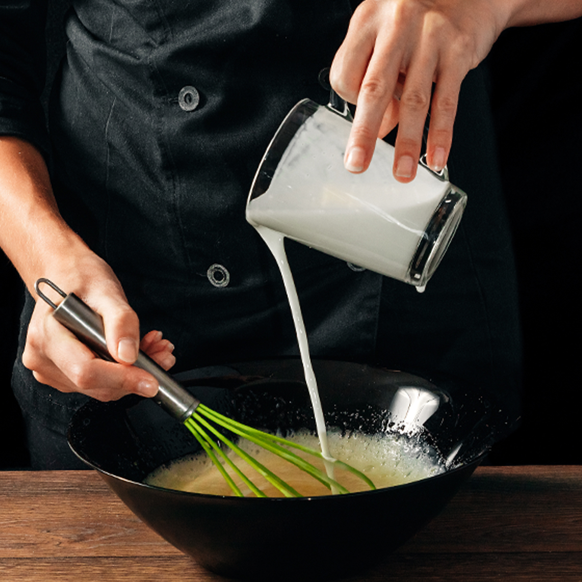 person pouring milk into a bowl