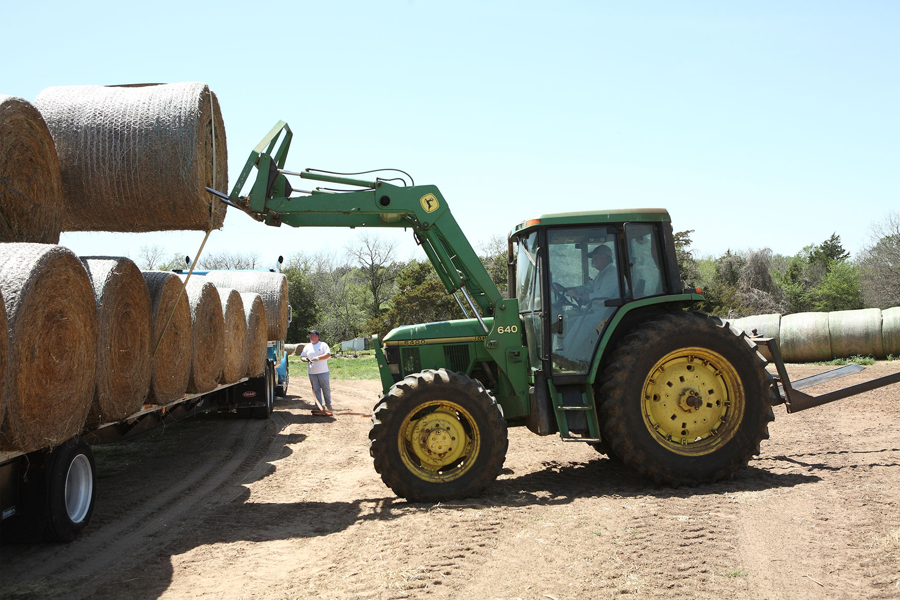 Putting hay bales on a truck for transport.